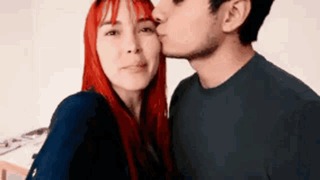a man is kissing a woman on the cheek
