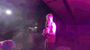 a man playing a guitar in a dark room