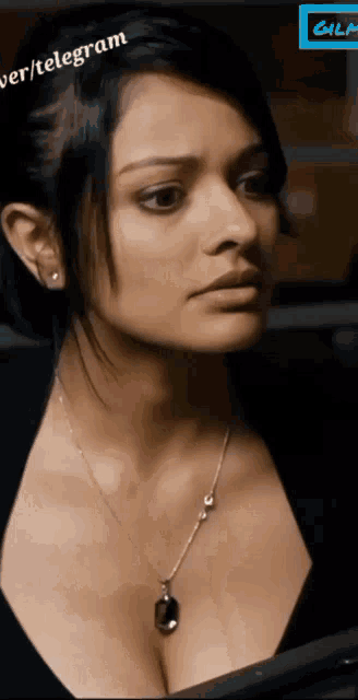 a close up of a woman wearing a necklace with the word telegram on the bottom