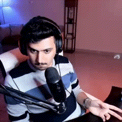 a man wearing headphones is sitting in front of a microphone in a living room .