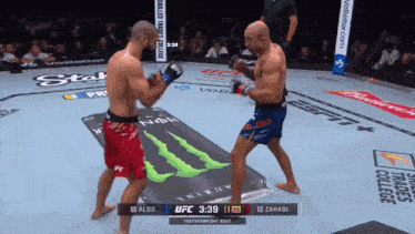 two men are fighting in a boxing ring with a monster energy drink advertisement in the background