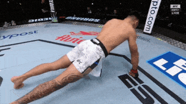a man in ufc shorts is doing a stretch