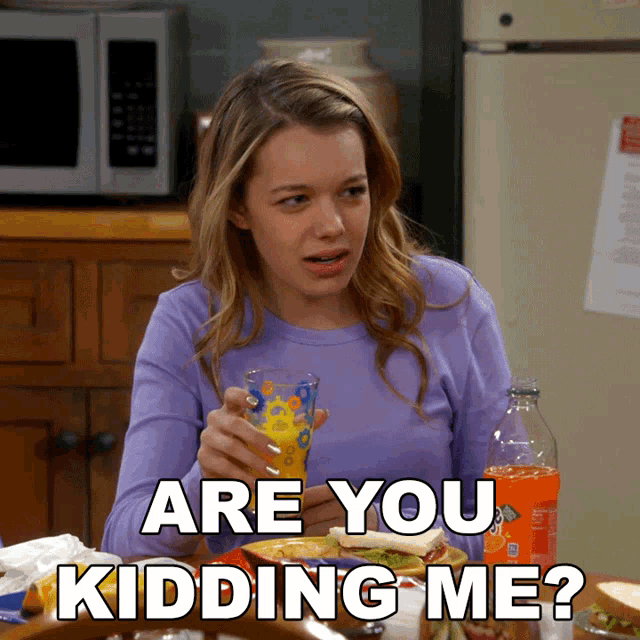 a woman sitting at a table with a glass of orange juice and the words " are you kidding me " below her