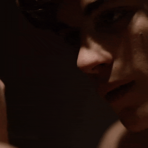 a close up of a man 's face with a hand on his face