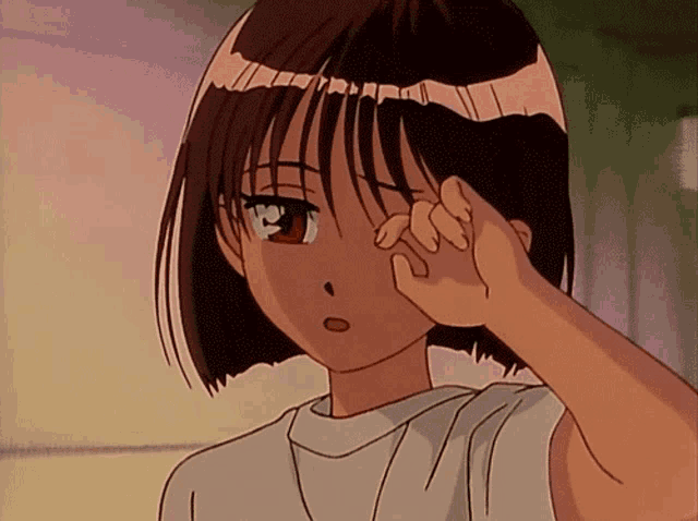 a girl in a white shirt is rubbing her eyes