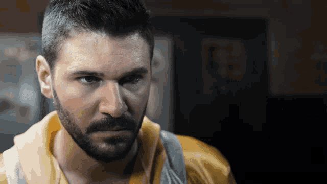 a man with a beard wearing a yellow shirt