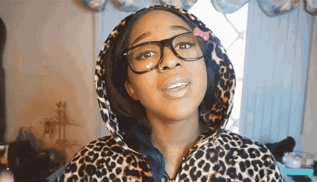 a young girl wearing glasses and a leopard print hoodie