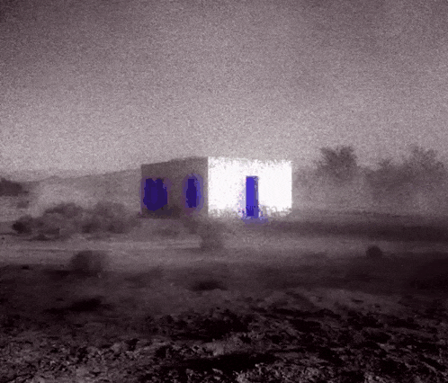 a black and white photo of a house with a blue door in the middle of a field .