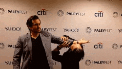 two men are posing for a picture in front of a wall with logos for citi and yahoo .