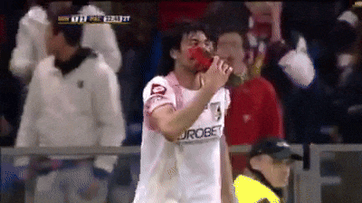 a soccer player wearing a eurobet jersey drinks from a can