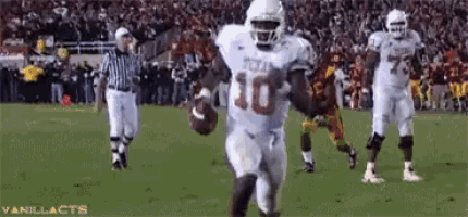 a football player with the number 10 on his jersey is running with the ball on a field .