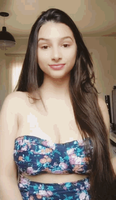 a woman with long hair wearing a floral top