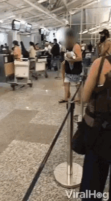 a woman is standing in a line at an airport waiting to check in .