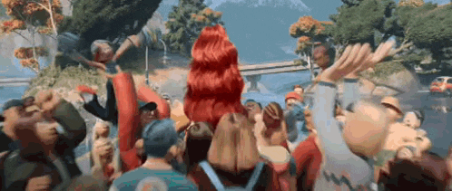 a group of people are standing in a crowd in front of a mountain .