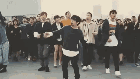 a group of people are dancing together and one of them is wearing a shirt that says ' tommy hilfiger '