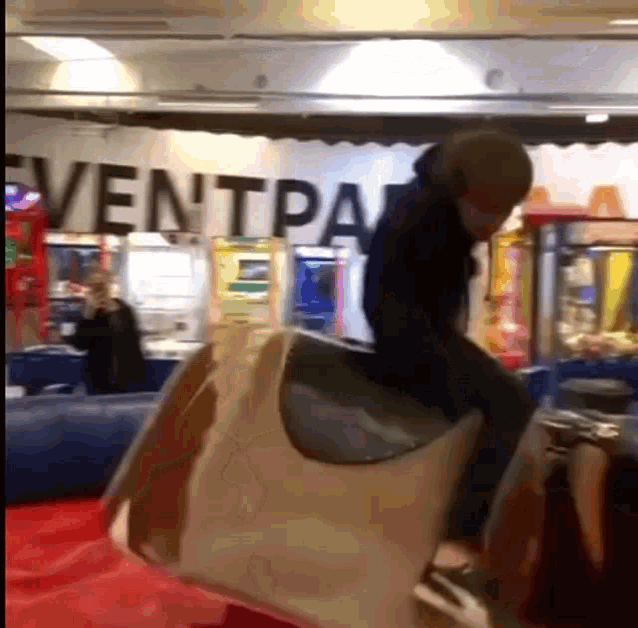 a man is riding a bull in front of a sign that says ventpal