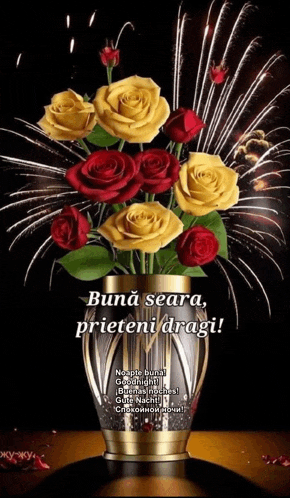a vase filled with red and yellow roses with fireworks in the background .