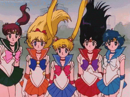 a group of sailor moon anime characters are standing next to each other .