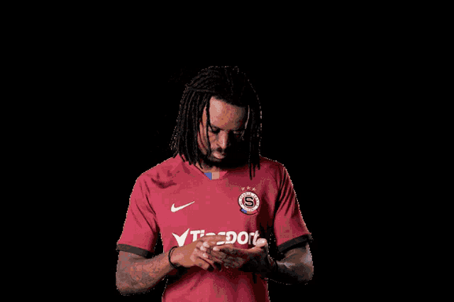 a man wearing a maroon jersey with the word tipsport on it