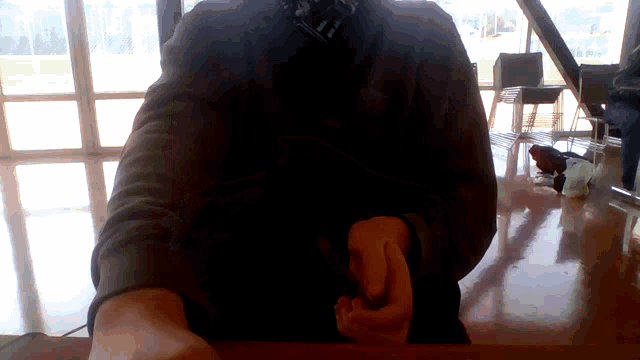 a person is sitting at a table with their arms outstretched