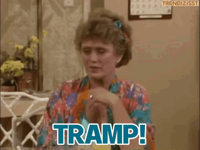 a woman is sitting at a table and saying tramp !
