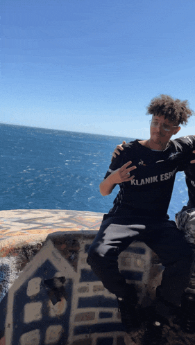 a man wearing a black t-shirt that says ' klanik esp ' on it