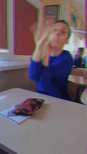 a blurry picture of a boy sitting at a desk