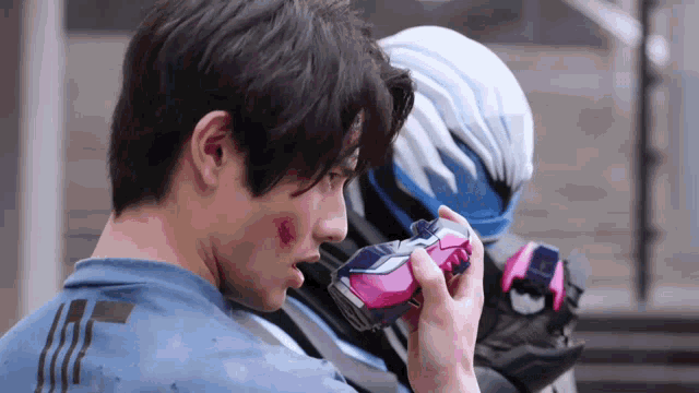 a man in a blue shirt is holding a pink and blue object