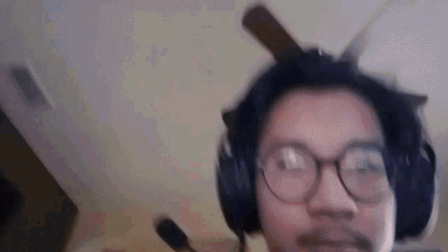 a man wearing glasses and headphones is looking at the camera .