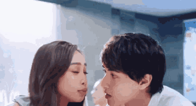 a man and a woman are kissing each other on the forehead .