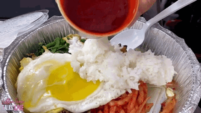 someone is pouring sauce into a foil container with rice and eggs with the words talk to me on the bottom