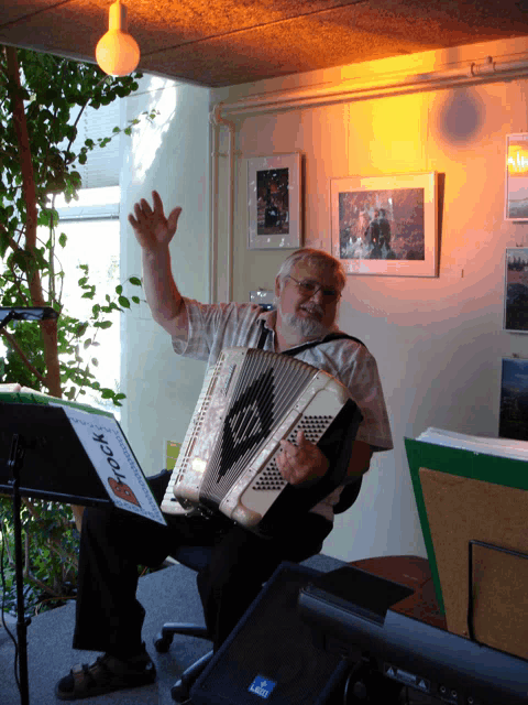 a man playing an accordion with a sign that says heck