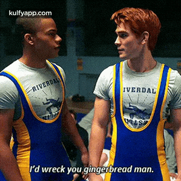 two wrestlers are standing next to each other and one of them is saying i 'd wreck you gingerbread man .