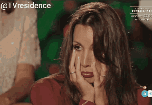 a woman with her hands on her face is on a tv screen with the words @tvresidence above her