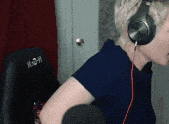 a person wearing headphones is sitting in a chair that says madm on the back