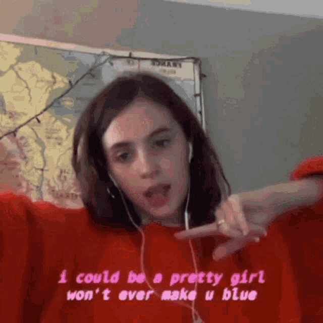 a girl wearing headphones and a red sweater is making a funny face
