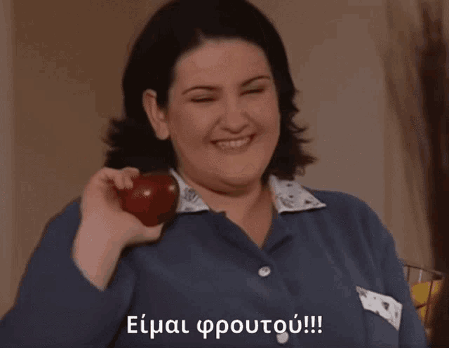 a woman in a blue shirt is holding a red apple and the words eimai froutou !!! are on the bottom