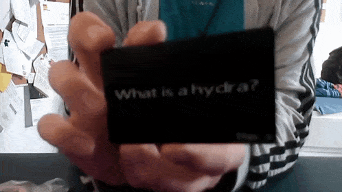 a person is holding a black card that says what is a hydra