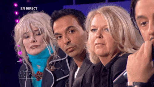 a group of people sitting in front of a screen that says en direct on it