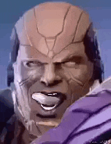 a close up of a man 's face with his tongue out and a helmet on .