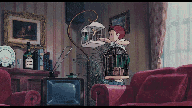 a boy is holding a bird cage in front of a television