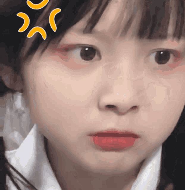 a close up of a girl 's face with a yellow sticker on her forehead