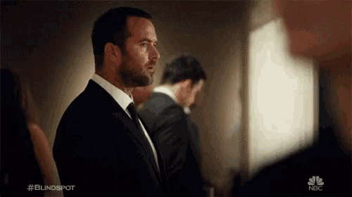 a man in a suit and tie is standing in front of a group of people .
