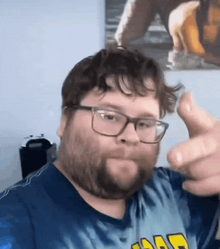 a man with a beard and glasses is giving a thumbs up .