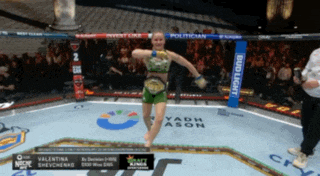 a woman in a boxing ring with a bud light banner on the corner