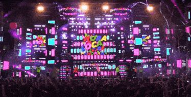 a crowd of people are gathered in front of a stage that has a sign that says coral