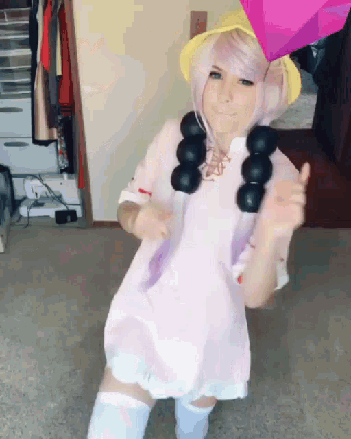 a girl in a pink dress is dancing with a pink umbrella