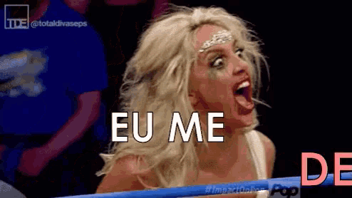 a woman in a wrestling ring with her mouth open and the words eu me behind her