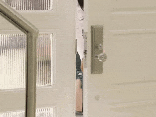 a woman standing in a doorway with a suitcase in her hand