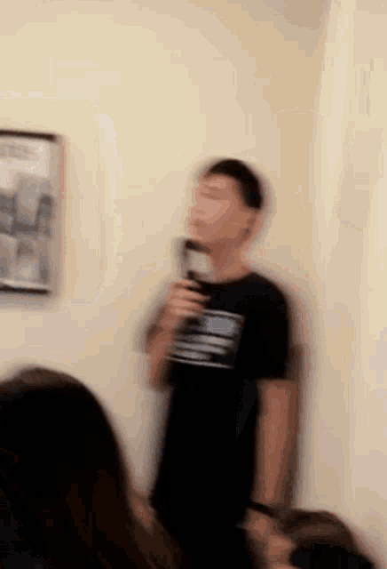 a blurry picture of a man in a black shirt holding a microphone .